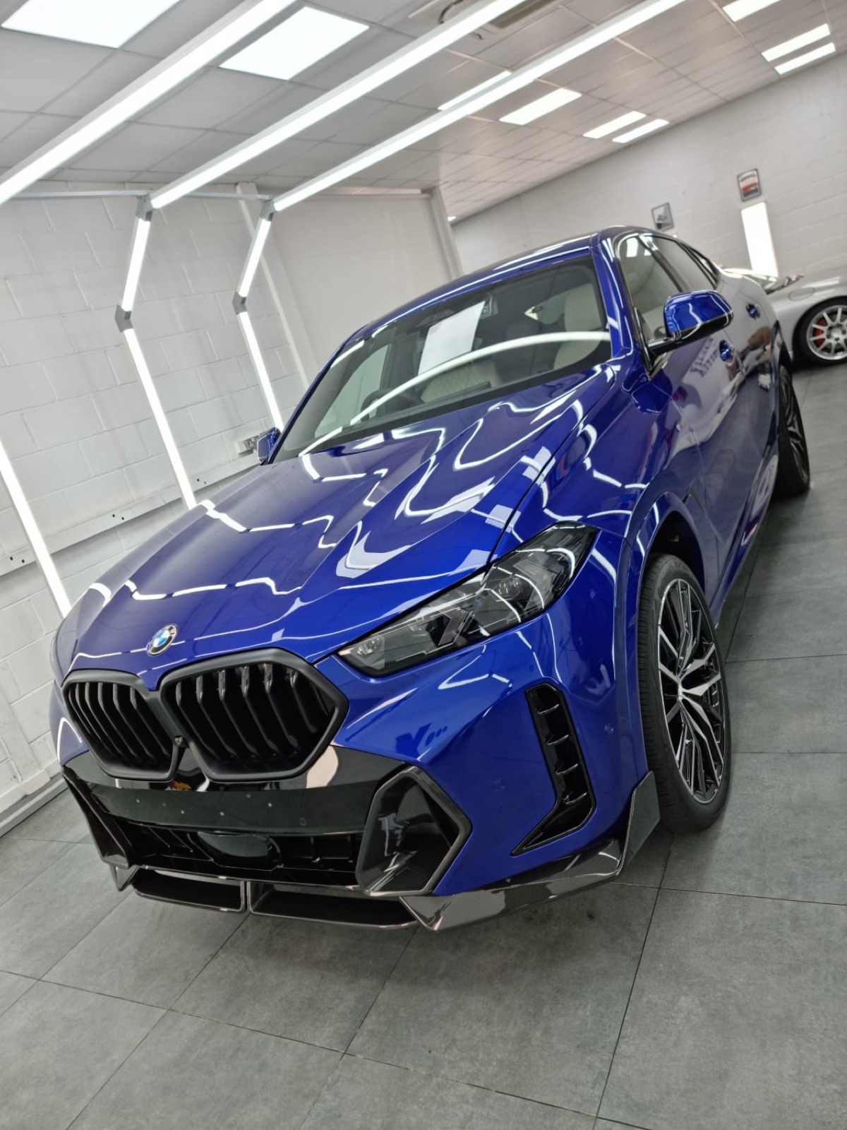 A car raised on the ramp inside the 5 Star Hand Car Wash and Valeting workshop bay